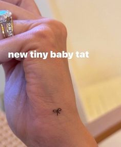 a woman's wrist with a tiny baby tat on the left side of her arm