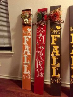 four wooden christmas signs hanging on the wall in front of a window with holiday decorations