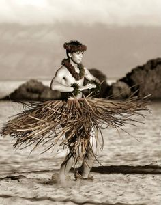 a man is standing in the water with some grass on his head and wearing a hula skirt