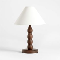 a wooden table lamp with a white shade on the top and bottom part of it