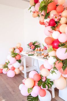 an image of a table with balloons and flowers in the air on top of it