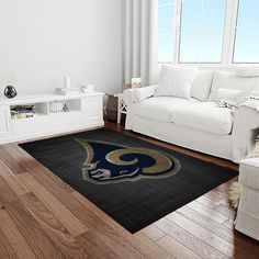 a living room filled with furniture and a rug on top of a hard wood floor