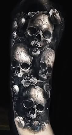 a man's arm covered in skulls and skulls on the inside of his arm