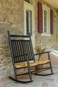 a rocking chair sitting on top of a stone patio