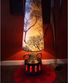 a lamp that is sitting on top of a red table cloth next to a black and white lamp