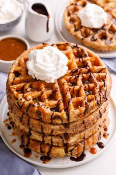 a stack of waffles topped with whipped cream