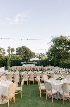 an outdoor wedding reception setup with tables and chairs