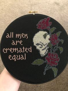 someone is holding up a cross - stitch embroidery project