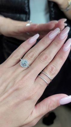 a woman's hand with two rings and a ring on her finger, holding onto another