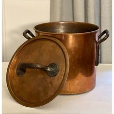 an old copper pot with a lid and handle