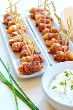 small appetizers are arranged on trays with toothpicks and ranch dressing