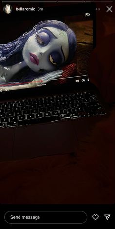 an image of a laptop with a creepy doll on it's keyboard and the screen is lit up