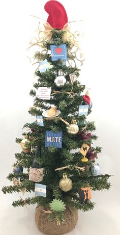 a small christmas tree with ornaments on it and a santa hat hanging from the top