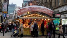 people are walking around an outdoor christmas market