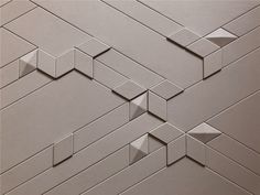 an abstract wall made up of small squares and rectangles in grey tones with white background