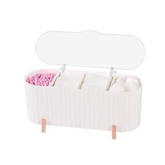 a white box filled with lots of pink and white candy next to an empty mirror