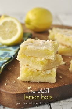 lemon bars stacked on top of each other with two lemons in the back ground