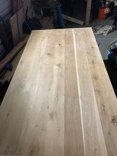 a wooden table in a garage with tools on the floor