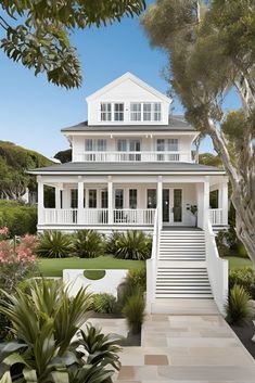 a large white house surrounded by trees and plants