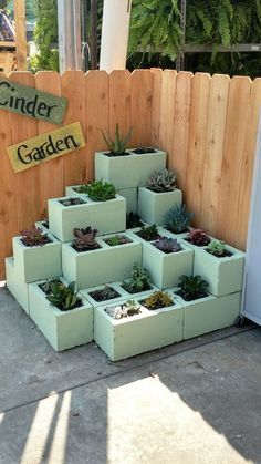 a bunch of planters that are sitting on the ground in front of a fence