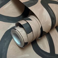 a roll of tape sitting on top of a wallpaper covered in black and white circles