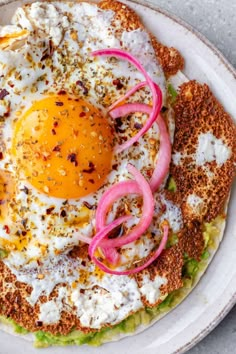 an egg is on top of some sort of bread with onions and other toppings