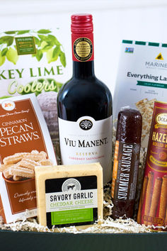 an assortment of wine, cheese and snacks in a box