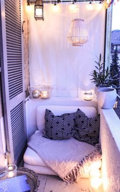 a purple couch sitting on top of a wooden floor next to a white wall covered in lights