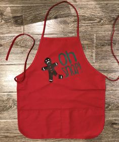 a red apron with an image of a black teddy bear on it that says, no stop