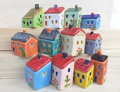 small ceramic houses are stacked on top of each other in the shape of houses,