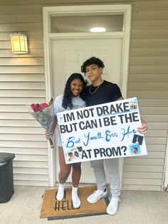 two people standing in front of a door holding a sign that says i'm not broke but can be the best you'll get at prom?