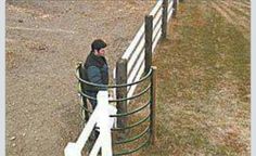 a man standing next to a white fence in front of a horse pen with another person looking over the fence