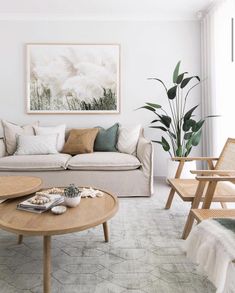 a living room filled with furniture and a painting on the wall above it's coffee table