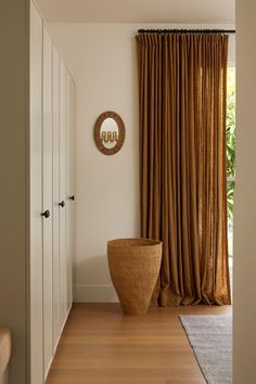 a large vase sitting in the middle of a room next to a window with drapes