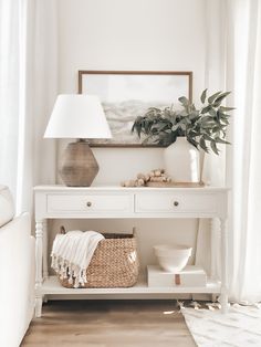 a white table with a basket and lamp on it