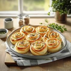 a platter filled with rolls sitting on top of a wooden table