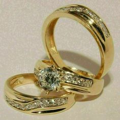 two gold wedding rings with diamonds on each one and an engagement ring in the middle