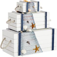 three white boxes are stacked on top of each other with starfish and seashells