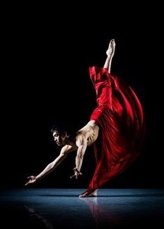 a woman in a red dress is doing a dance move with her legs spread out