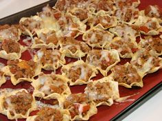 a red tray filled with stuffed shells covered in meat and cheese