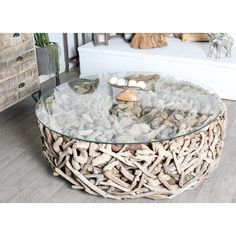 a glass table topped with lots of rocks and shells on top of a hard wood floor