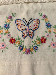 embroidered butterfly on white linen with colorful flowers