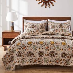 a bedroom with a bed, night stand and clock on the wall above it that is decorated in floral patterns