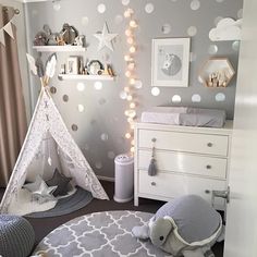 a baby's room with polka dot wallpaper and a teepee tent in the corner