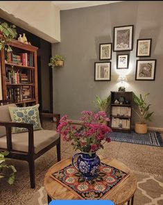 a living room filled with lots of furniture and flowers on top of a coffee table