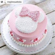 a pink and white cake with a minnie mouse on top