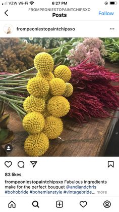 some flowers are sitting on top of a wooden table and the caption says,