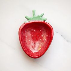 a close up of a red object on a white table with a green decoration in the middle