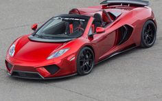 a red sports car driving down a race track with its doors open and the top down