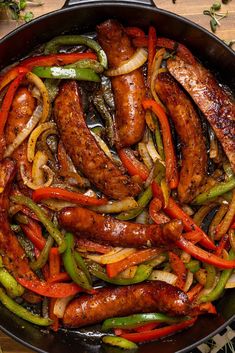 sausages and peppers are cooking in a skillet